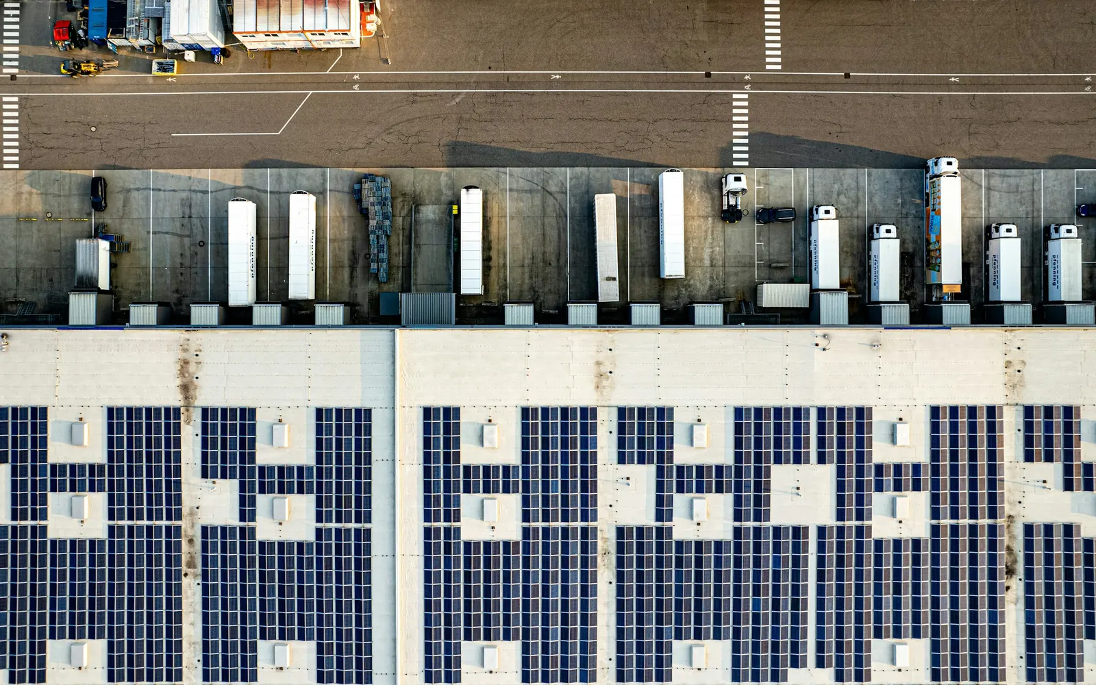 Aerial view of a commercial building with rooftop solar panels and loading bays